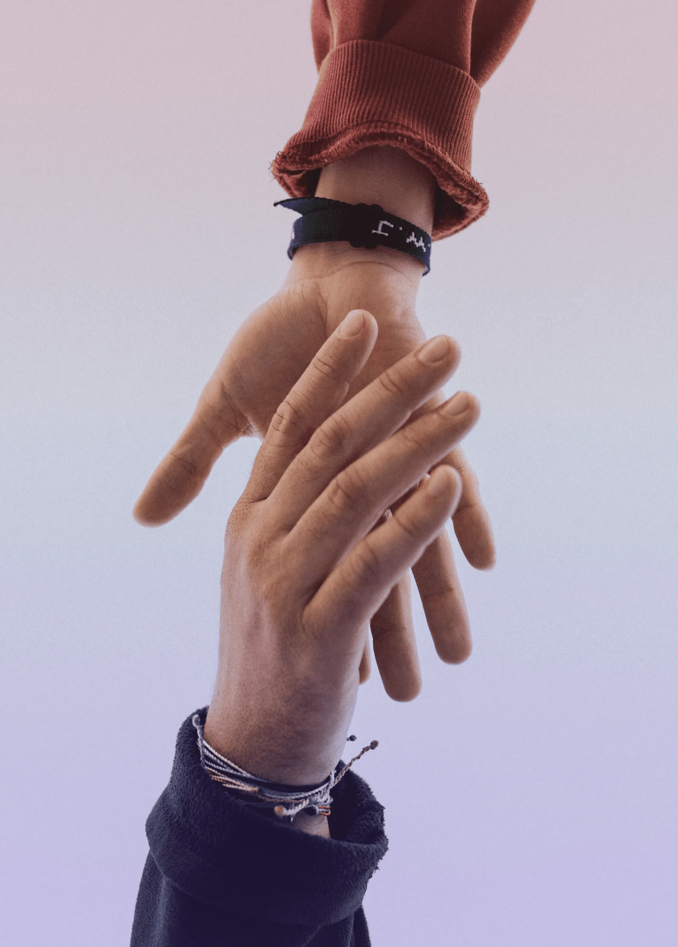 One hand reaching down to take hold of another.